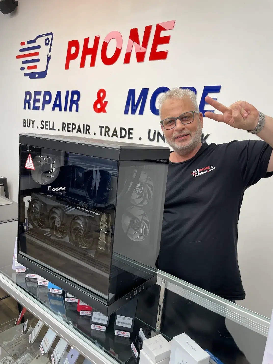 Phone Repair & More team member beside a custom gaming PC in Wesley Chapel