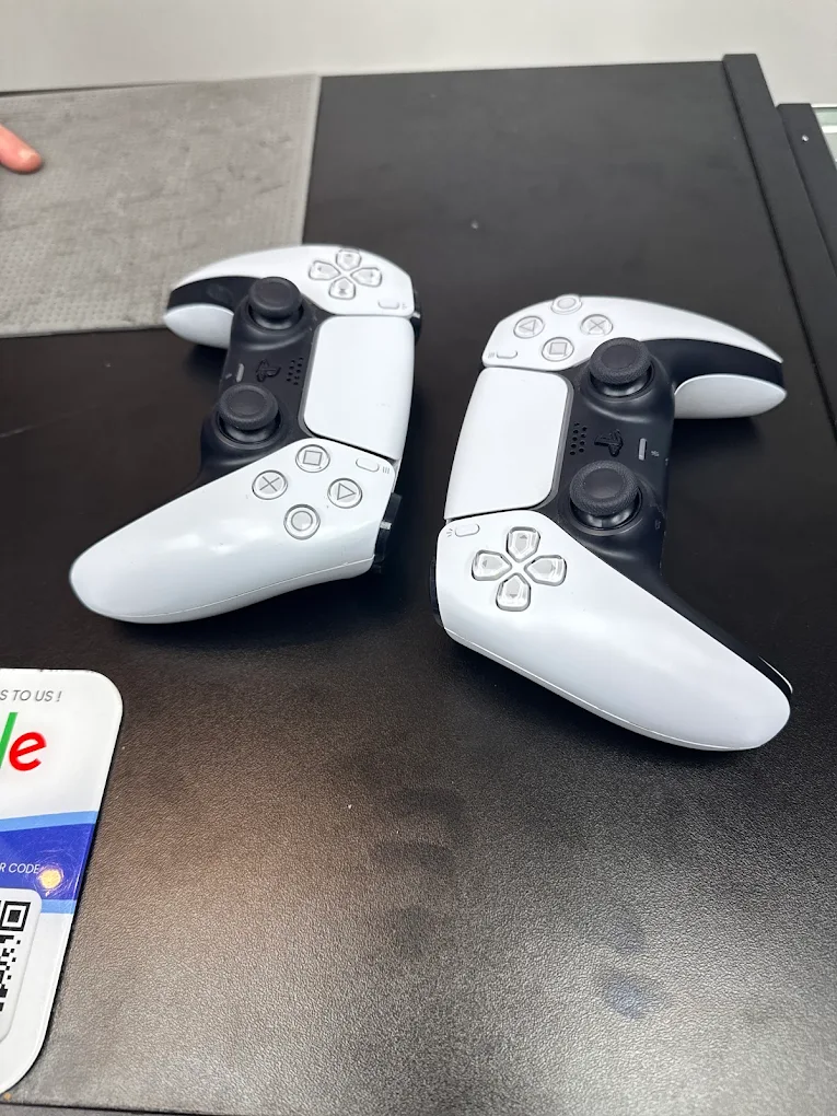 Two PS5 DualSense controllers on the Wesley Chapel repair bench for stick drift repair