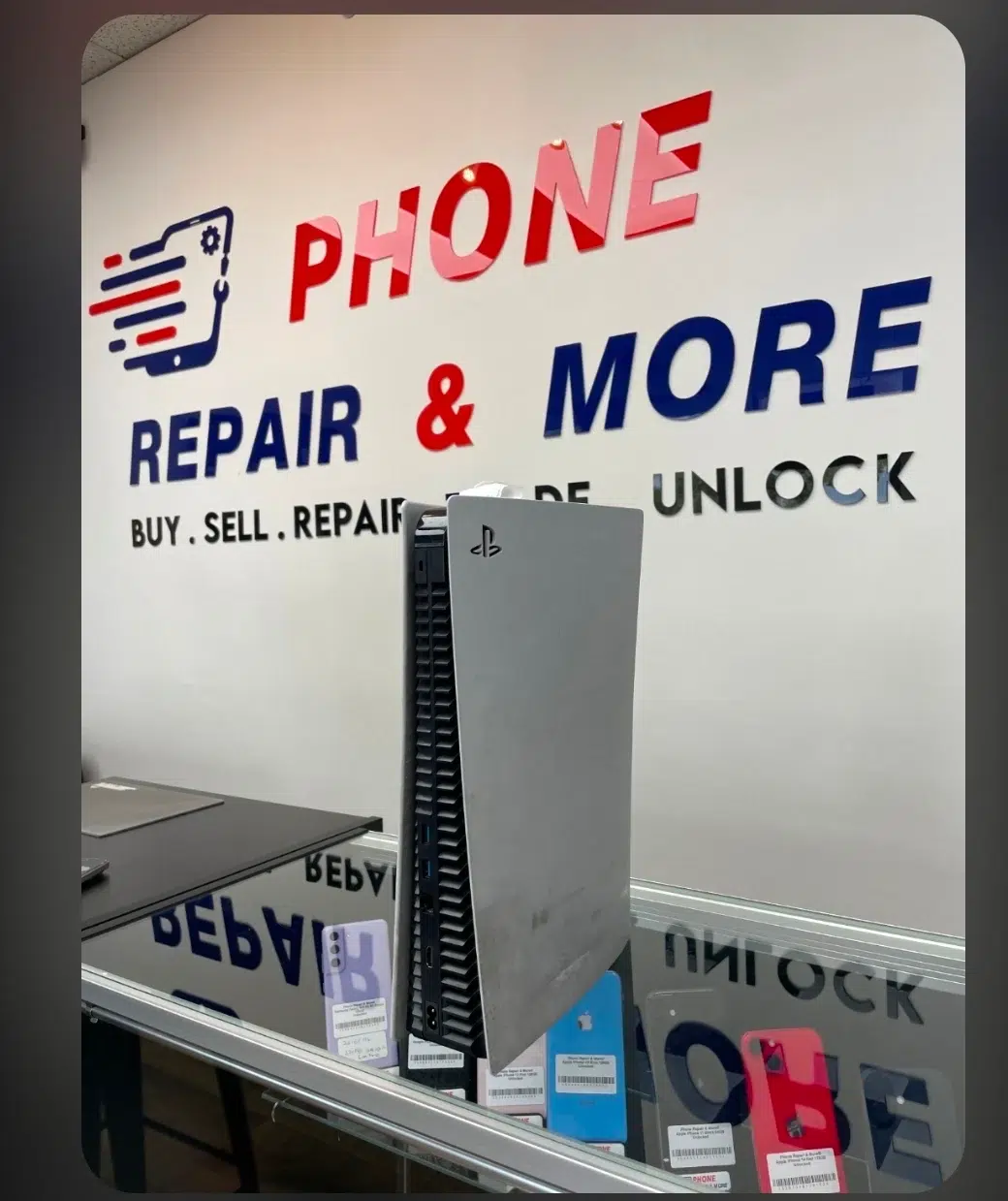 PS5 console on the counter in front of the Phone Repair & More sign in Wesley Chapel