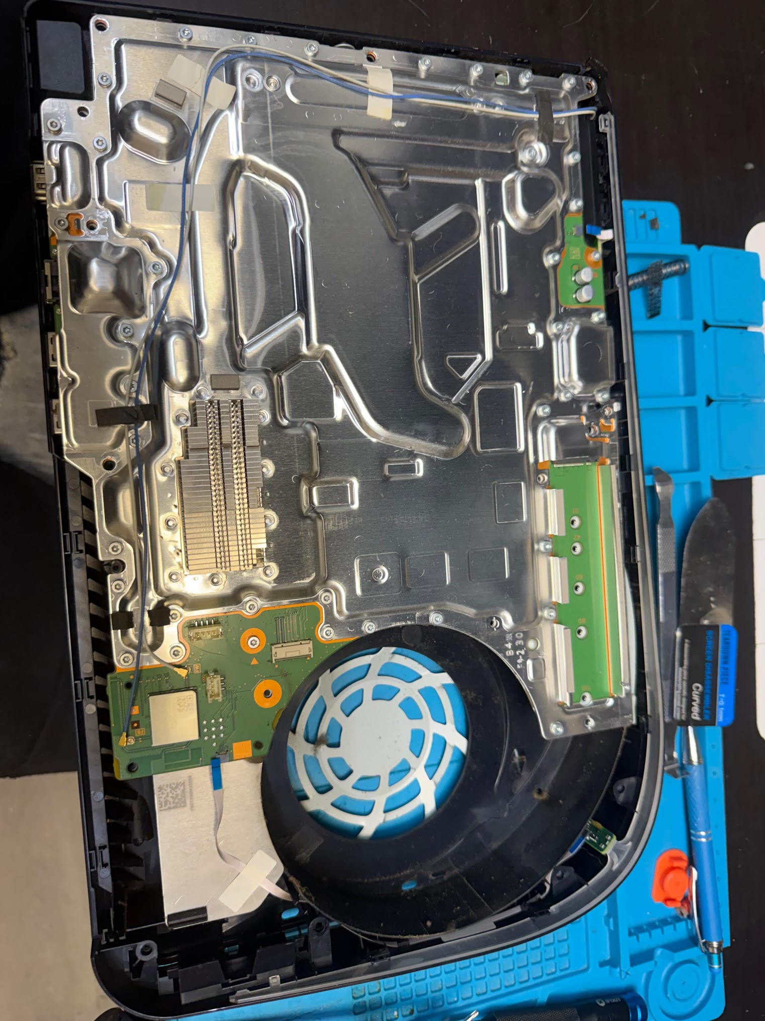 PS5 opened on the repair bench with the motherboard exposed at Phone Repair & More in Tampa